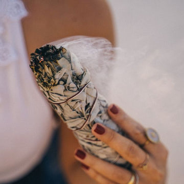 Woman smudging with Medium white sage smudge stick - cleansing and purifying